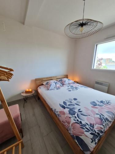 Schlafzimmer mit einem Bett und einem Fenster in der Unterkunft Les Loguyviennes in Ploubazlanec