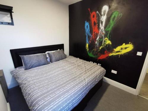 a bedroom with a bed with a poster on the wall at The Bob Marley 'One Love' Apartment, Relaxed Vibes in Liverpool
