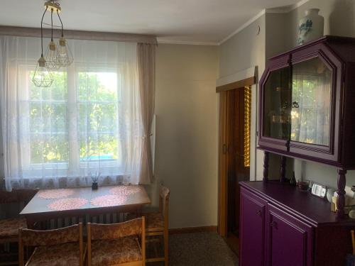 a dining room with a purple table and a window at Domek nad morzem in Sopot