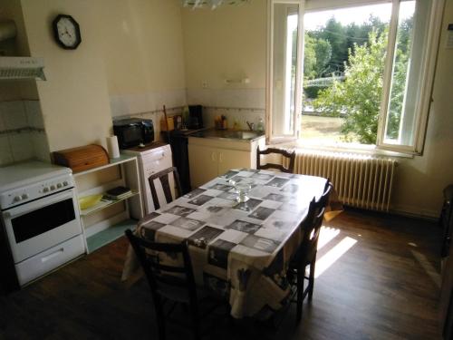 a kitchen with a table with chairs and a window at Maison de vacances à Miramont-de-Guyenne in Miramont-de-Guyenne