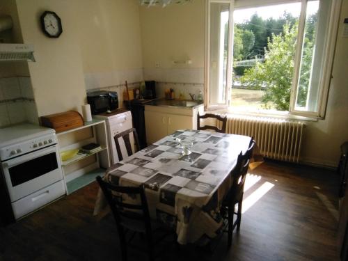 une cuisine avec une table et des chaises ainsi qu'une fenêtre dans l'établissement Maison de vacances à Miramont-de-Guyenne, à Miramont-de-Guyenne