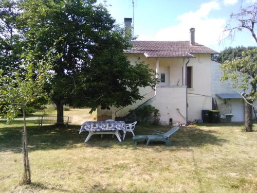 a picnic table and a bench in front of a house at Maison de vacances à Miramont-de-Guyenne in Miramont-de-Guyenne