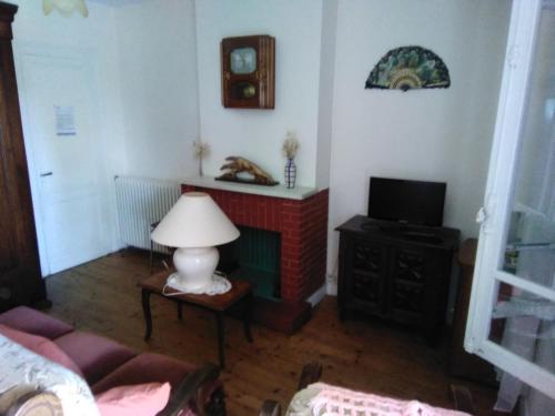 a living room with a lamp and a tv at Maison de vacances à Miramont-de-Guyenne in Miramont-de-Guyenne