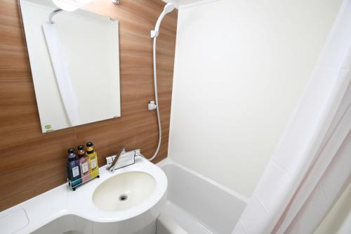 a bathroom with a sink and a mirror at Marroad inn omiya in Saitama