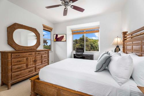 - une chambre avec un lit, un miroir et une commode dans l'établissement Mauna Lani Fairways 504, à Waikoloa