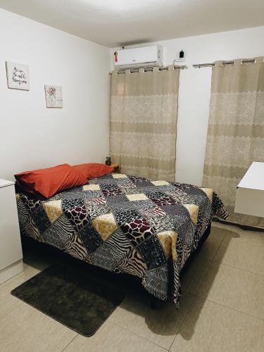 um quarto com uma cama com uma colcha em Bangalô duplex 602 - Riviera do Atlântico em Conde