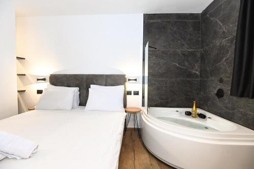 a bedroom with a bed and a bath tub next to a bath tub at Selfie's Boutique Hotel in Tiberias