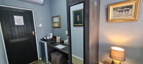 a room with a hallway with a desk and a mirror at Kairos Guesthouse Orania in Orania