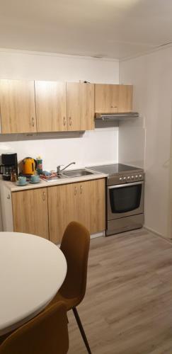a kitchen with a table and a stove and cabinets at Studio 2 in Dalen