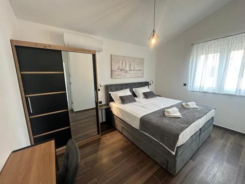 a bedroom with a large bed and a window at Apartments Pina in Kornić