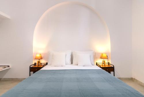 Ce lit se trouve dans un dortoir blanc doté de 2 lampes. dans l'établissement Petrina Volia - Residence Anemos, à Andros