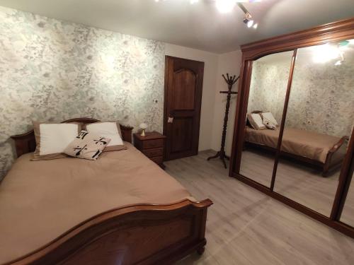 a bedroom with a large bed and a mirror at Chambre d’hotes chez Sylviane in Niederhergheim