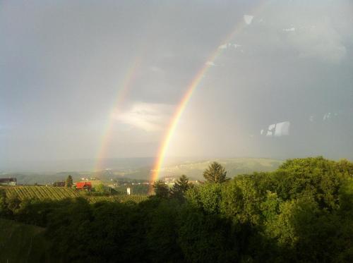 a double rainbow in the sky over a vineyard at Wohlmuth-Lückl in Kitzeck im Sausal