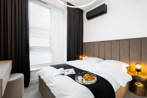 a hotel room with a bed with a bowl of fruit on it at Best Apartment SPA in Rzeszów
