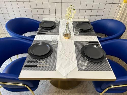 a table with blue chairs and a table with plates and napkins at holy home in Mestre