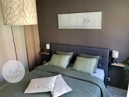 a bedroom with a bed with two pillows at Appartement Sealight in De Haan
