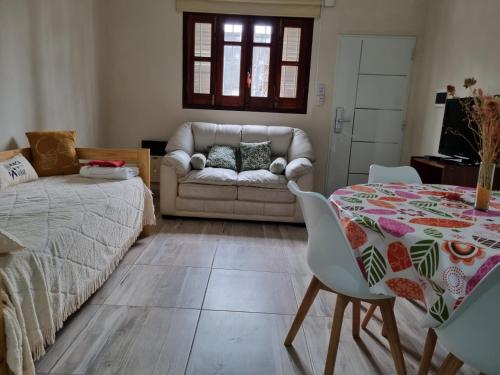 a living room with a table and a couch at Casa Céntrica con acceso autónomo in Rafaela