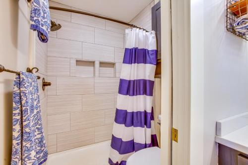 a bathroom with a shower with a blue and white shower curtain at Gorgeous Onekama Condo with Pool and Lake Access! in Onekama