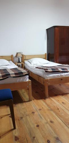 2 camas en una habitación con suelo de madera en Guest House Svan-Ski, en Mestia