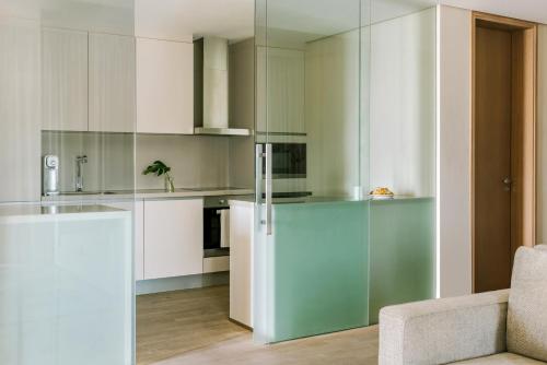 een keuken met witte kasten en een glazen koelkast bij Sonder at JBR The Walk in Dubai