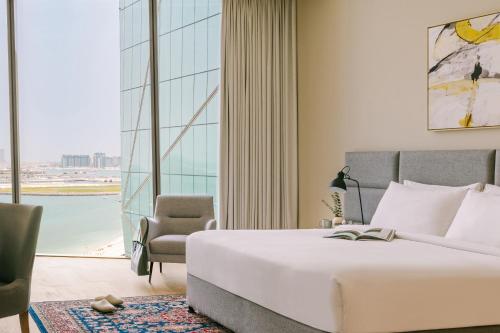 Sonder at JBR The Walk في دبي: غرفة نوم بسرير وكرسي ونافذة كبيرة