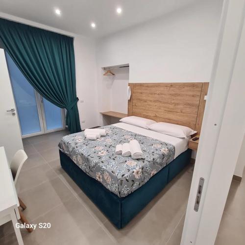 a bedroom with a bed with two towels on it at Residenza Nascari al Plebiscito in Naples