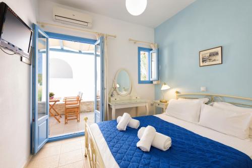 a bedroom with a blue bed with white pillows at Kostantis Vacation Home 1 in Ambelas