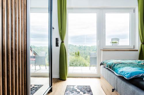 a bedroom with a bed and a sliding glass door at Neu stilvoll komplett Ausgestattet Fewo Gratis Wein und Getränke bei Ankunft in Saldenburg