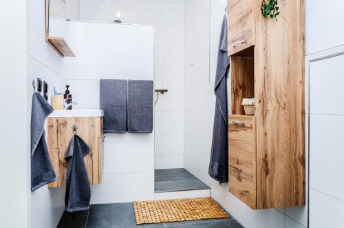 een badkamer met een douche en een houten deur bij Neu stilvoll komplett Ausgestattet Fewo Gratis Wein und Getränke bei Ankunft in Saldenburg
