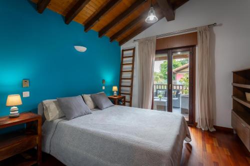 een slaapkamer met een bed met een blauwe muur bij Paraisos Connecta in Cubas