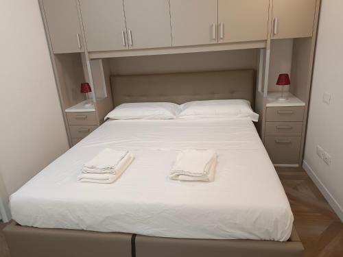 - un lit blanc avec 2 serviettes dans l'établissement Luminoso Bilocale zona Tibaldi Bocconi, à Milan