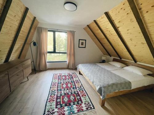 een slaapkamer met een groot bed en een tapijt bij Zminica Lake House in Žabljak