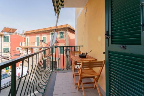 einen Balkon mit zwei Stühlen und einem Tisch darauf in der Unterkunft 195 - Casa Ca Du Fiore, 20 minuti dal mare di Sestri in Castiglione Chiavarese