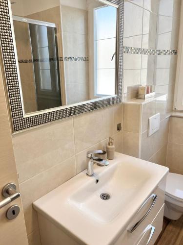 a bathroom with a sink and a mirror and a toilet at Luxury apartment Aura in Supetar