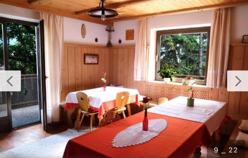 uma sala de jantar com duas mesas e duas janelas em Haus Käfersberg em Naturno