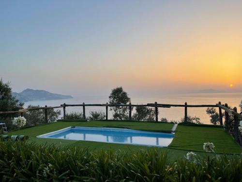 a pool with a view of the ocean at sunset at Farm seaview on Capri in Termini