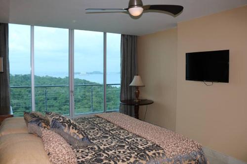 1 dormitorio con 1 cama y TV de pantalla plana en 21P Penthouse 2 balconies Oceanview Panama, en ArraijÃ¡n