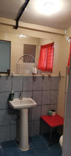 a bathroom with a sink and a red window at Casa Kitus in San José