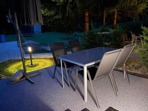 a blue table and chairs in a backyard at night at Apartmani Vukman in Delnice