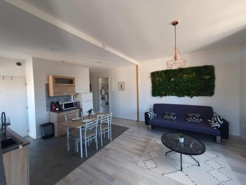 un salon avec un canapé bleu et une table dans l'établissement Mâcon • T2 St Vincent • HostisY, à Mâcon