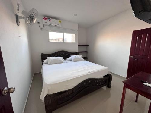 1 dormitorio con 1 cama con sábanas blancas y ventana en Hotel Casa Evan, en Mompox