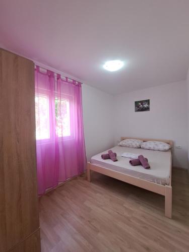 a bedroom with a bed and a purple door at Flower in Poljica