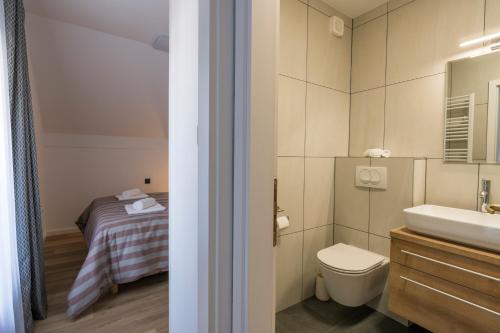 スヴェティ・マルティン・ナ・ムリにあるMARTINUS-Vのバスルーム(洗面台、トイレ付)、ベッド1台が備わります。