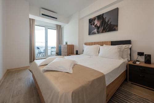 um quarto com uma cama grande e uma janela grande em Crystal Beach 228 - Infinity Pool & Spa Resort em Mamaia Nord – Năvodari