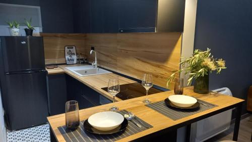 a kitchen with a table with two glasses of wine at Comfort Apartment 2 in Shkodër