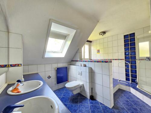 baño azul y blanco con lavabo y aseo en Wohnreich Blaustein Mitte -3B- 2er WG en Blaustein