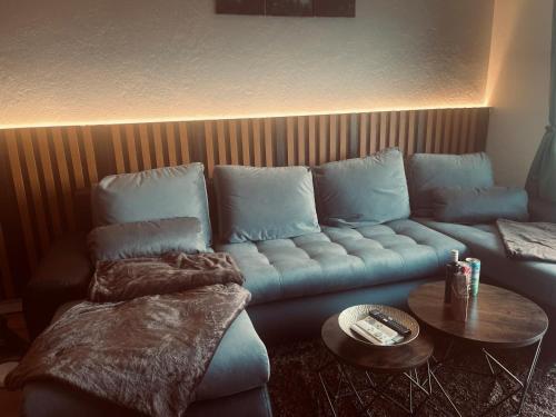 a living room with a blue couch and a table at Stilvolle Ferienwohnung mit Blick in die Natur in Saldenburg