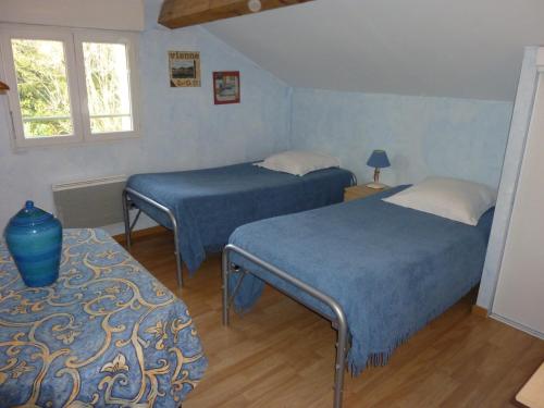 1 dormitorio con 2 camas y mesa con lámpara en Gîte du Tilleul, en Vienne