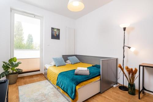 ワルシャワにあるStawki Watermelon Apartmentのベッドルーム1室(黄色と青の毛布付きのベッド1台付)