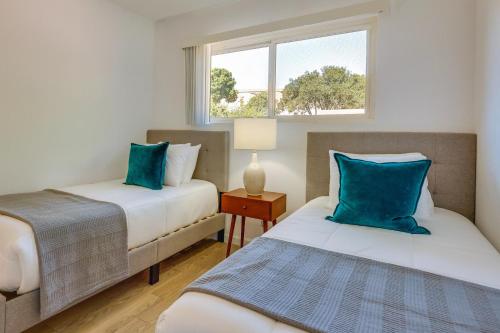 2 camas con almohadas azules en una habitación con ventana en Inviting Home with Patio Walk to Downtown Novato!, en Novato